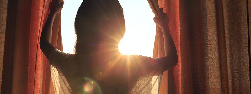 girl opening curtains